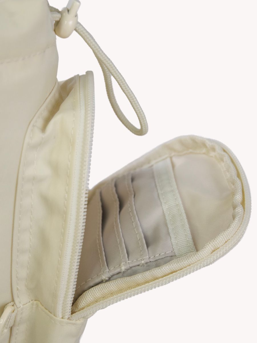 Inside of the front pocket for the beige antitheft travel water bottle bag including 3 RFID protected card slots, pocket for iPhone and separate slip pocket for keys, lip balm and small items