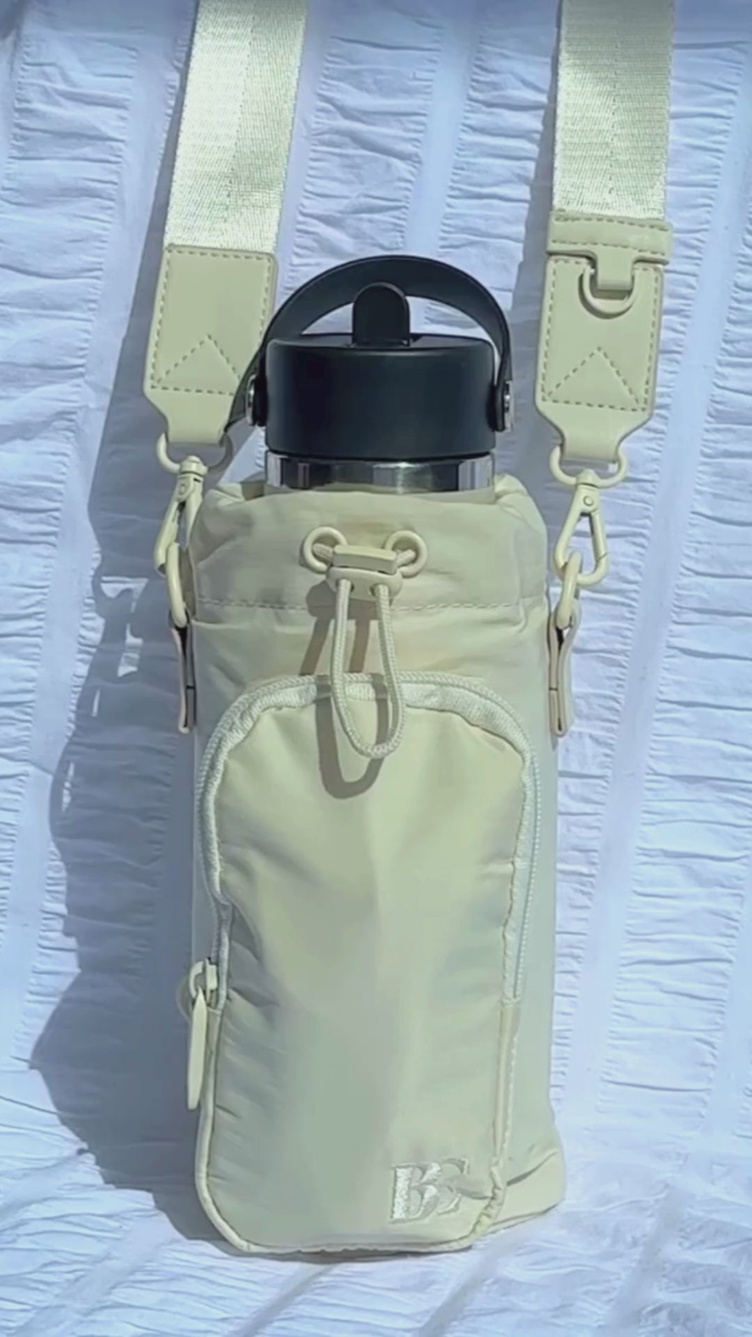 Load video: Video demonstrating the spacious front pocket of the anti-theft water bottle bag. Items are removed one by one, including an iPhone Pro Max, keys, a lip balm, and three cards, showcasing the bag&#39;s functionality and capacity. The sleek design and practicality are highlighted throughout